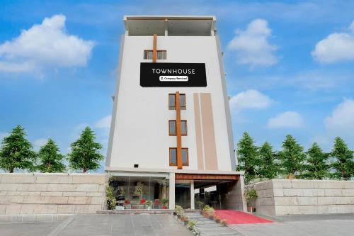 a building with a tower with a sign on it at Super Townhouse Sri Padmavati Ammavaari Temple Formerly Hotel Rama Grand in Tirupati