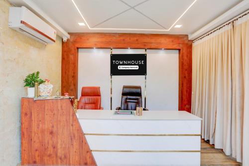 an office with a reception desk and a sign that reads luxurious at Super Townhouse Sri Padmavati Ammavaari Temple Formerly Hotel Rama Grand in Tirupati