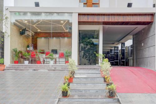 a building with a red carpet and stairs with plants at Super Townhouse Sri Padmavati Ammavaari Temple Formerly Hotel Rama Grand in Tirupati