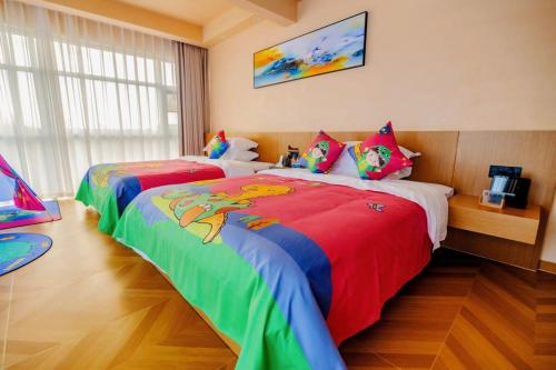 a bedroom with two beds with colorful blankets at Langying Intelligent Guesthouse in Changshancun