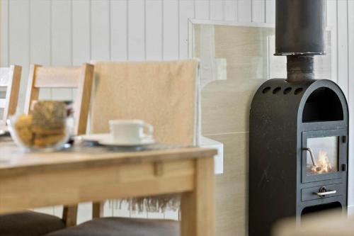 a wood fired stove sitting next to a table at 20218-Samso-Rosenvej-22 in Tanderup