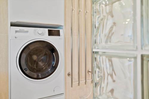 a washing machine is next to a glass door at 20218-Samso-Rosenvej-22 in Tanderup
