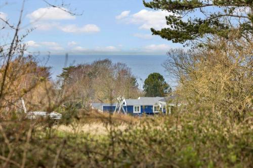 a blue house with the ocean in the background at 20218-Samso-Rosenvej-22 in Tanderup