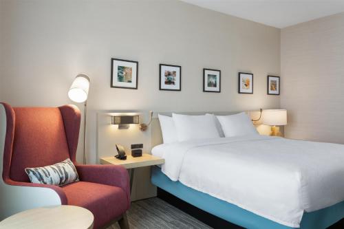 a hotel room with a bed and a chair at Hilton Garden Inn Austin Central in Austin