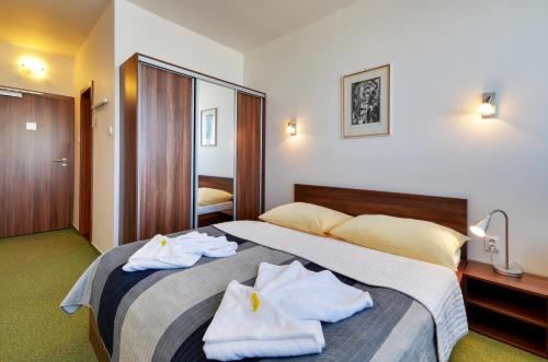 Una habitación de hotel con una cama con toallas. en Hotel Klar, en Liptovský Mikuláš