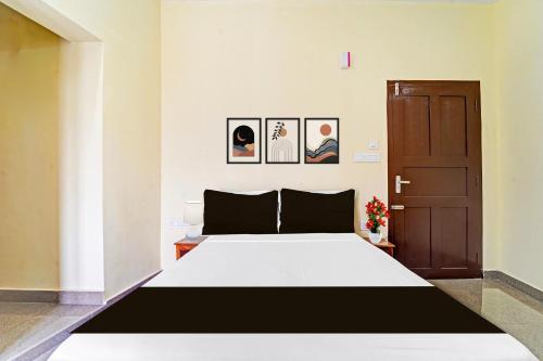 a bedroom with a large white bed and a door at Super Hotel O Omalloor Temple Formerly MTS Lodge in Pathanāmthitta