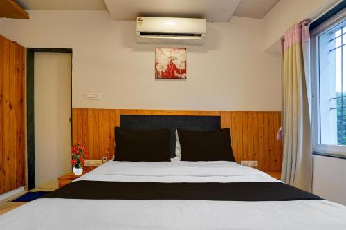 a bedroom with a bed and a window at Super Townhouse Oak Gravity Inn in Pune