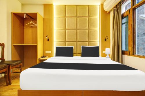 a bedroom with a large bed and a desk at Super Townhouse Rajbagh Formerly Hotel Modern in Srinagar
