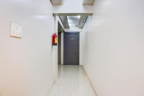 a hallway with a blue door in a building at Super Townhouse Oak Gravity Inn in Pune