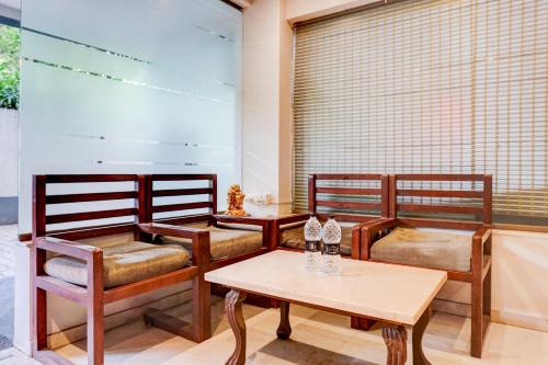 a room with three chairs and a table at Super Townhouse Oak Gravity Inn in Pune