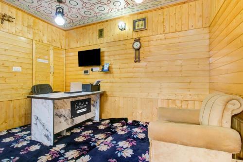 a room with a desk and a chair and a tv at Collection O Brein Nishat Formerly Continental Guest House in Srīnagar
