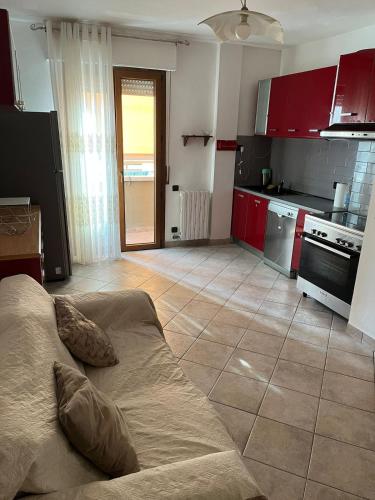 a kitchen with red cabinets and a couch in a room at Manuel House in Pisa in Pisa