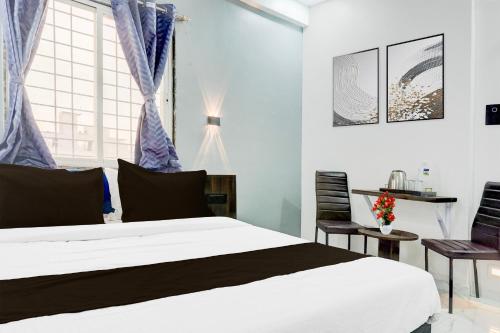 a bedroom with a white bed and a window at Super Townhouse Hinjewadi Corporate Stays in Pune