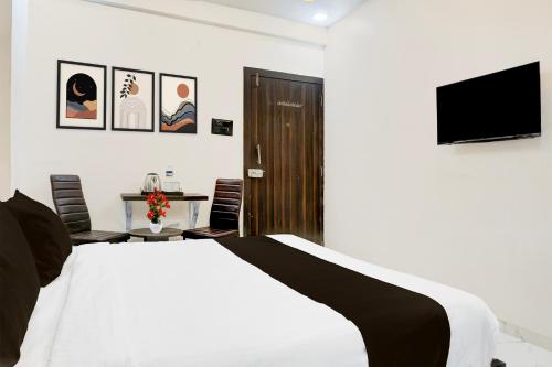 a bedroom with a bed and a tv on a wall at Super Townhouse Hinjewadi Corporate Stays in Pune