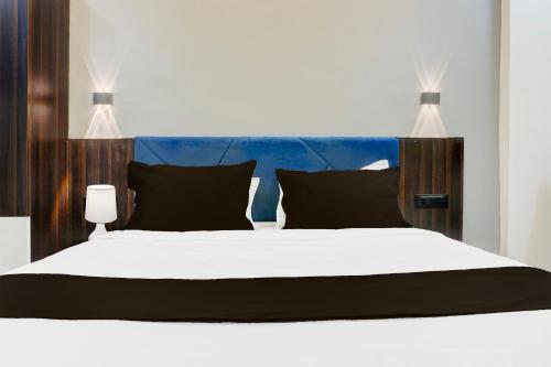 a bedroom with a large white bed with black pillows at Super Townhouse Hinjewadi Corporate Stays in Pune