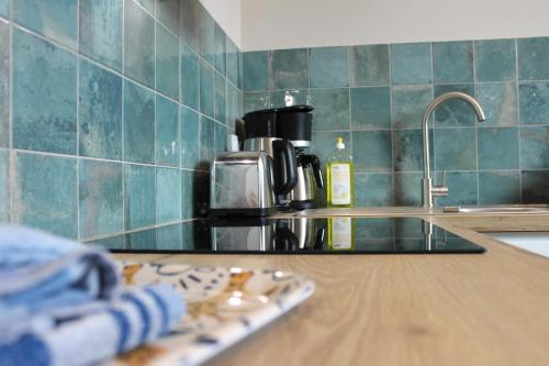 a kitchen counter top with a sink and a counter sidx sidx sidx at La Bullote - Gîtes - Paris Roissy CDG in Villeneuve-sous-Dammartin