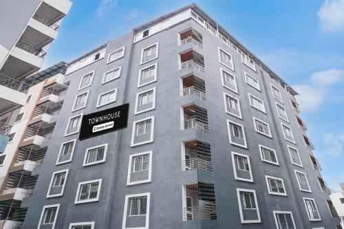 a tall gray building with a sign on it at Super Townhouse Hinjewadi Corporate Stays in Pune