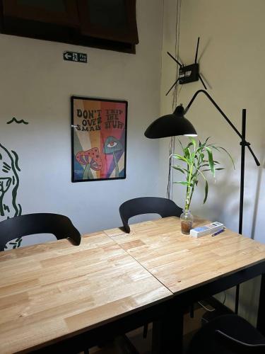 a wooden table with two chairs and a lamp at PROpaganda Hostel in Koh Phangan