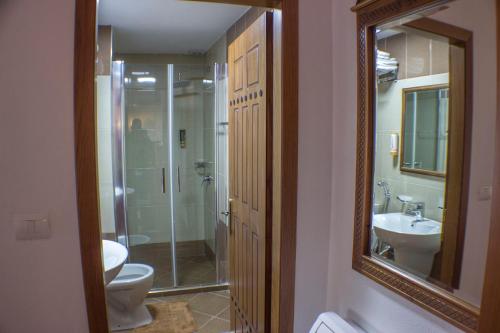 a bathroom with a toilet and a sink and a mirror at Old Bazaar 1790 in Gjirokastër