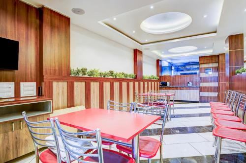 a restaurant with tables and chairs and a tv at Super Townhouse Zero Mile Gandhi Setu Formerly Classic Court in Gulzārbāgh