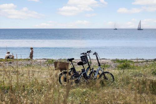 two bikes parked on a beach near the water at 20331-Samso-Vestergade-37 in Kolby
