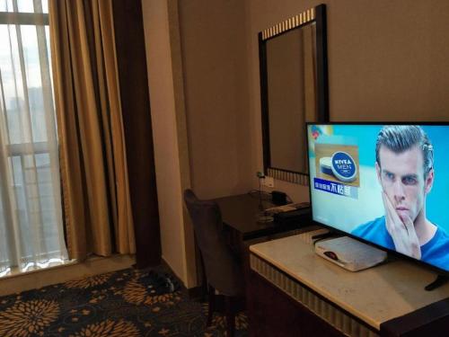 a computer monitor on a desk in a hotel room at Zhongshan Hui Quan Hotel in Zhongshan