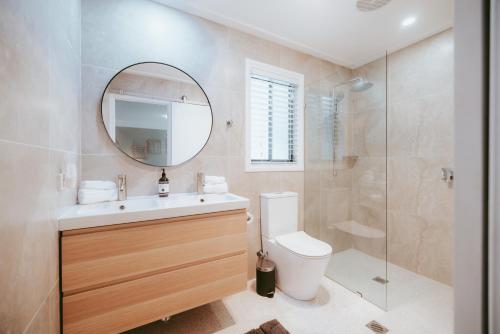 une salle de bain avec toilettes, lavabo et miroir dans l'établissement Jimmys Cabin - Kangaroos, Kookaburras, Sleeps 4!, à Kangaroo Valley