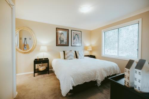 une chambre avec un lit blanc et une fenêtre dans l'établissement Jimmys Cabin - Kangaroos, Kookaburras, Sleeps 4!, à Kangaroo Valley
