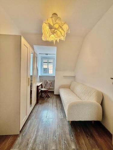 a living room with a couch and a chandelier at 1 room in Poznań