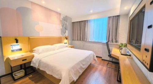 a bedroom with a large white bed and a window at GreenTree Inn Ganzhou Gan County Bus Station in Ganzhou