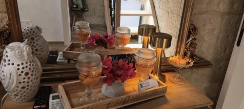 a table with glasses and flowers and a mirror at Palazzo Emy in Lecce