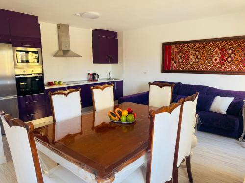 una cocina y una mesa con un bol de fruta. en Timeless Comfort Suites San Blas, en San Miguel de Abona