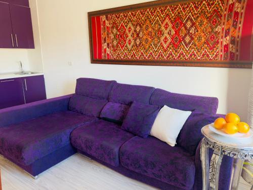 un sofá púrpura en una sala de estar con mesa en Timeless Comfort Suites San Blas, en San Miguel de Abona