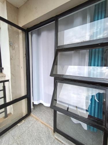 a glass shelf in a room with a window at Luxe Studio Kinoo in Rungiri