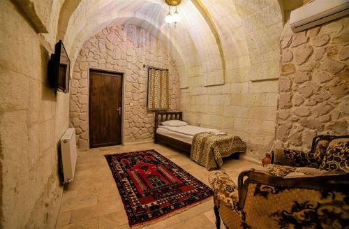 a bedroom with a bed in a stone building at Cappadocia Caves Hotel in Goreme