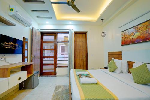 a bedroom with a bed and a desk and a television at Hotel Maharaja Palace Boutique Hotels Near Medanta Medicity Gurgaon in Gurgaon