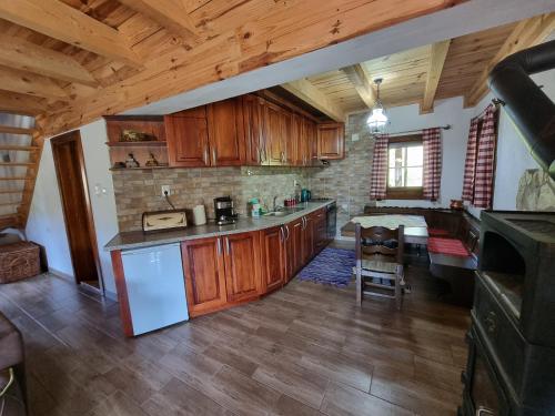 a large kitchen with wooden cabinets and a table at Country House Sunčev breg in Bara Slatina