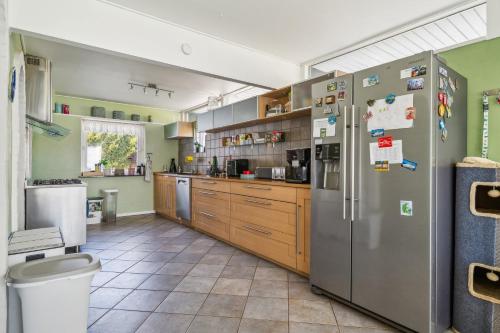 a kitchen with stainless steel appliances and wooden cabinets at Dutchies-dk in Væggerløse