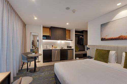 a hotel room with a bed and a kitchen at Littomore Suites Kingswood in Penrith