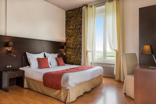 a bedroom with a large bed and a window at Manoir de Kerhuel de Quimper in Plonéour-Lanvern