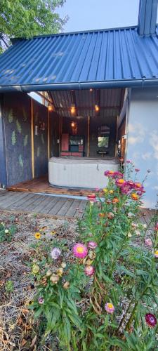 a house with a blue roof with flowers in front at Tweet Apartments with Sauna and optional Breakfast Close To Terme Sveti Martin in Štrigova