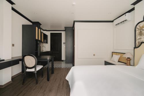 a bedroom with a bed and a desk and a table at Dom's Residence Hoan Kiem in Hanoi
