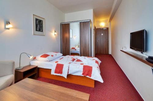 a hotel room with a bed and a flat screen tv at Hotel Klar in Liptovský Mikuláš