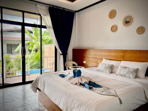 ein Schlafzimmer mit einem großen Bett, auf dem Handtücher liegen in der Unterkunft AMORA Lanta in Ko Lanta Yai