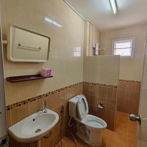 a bathroom with a toilet and a sink at The Shamrock in Bang Sare