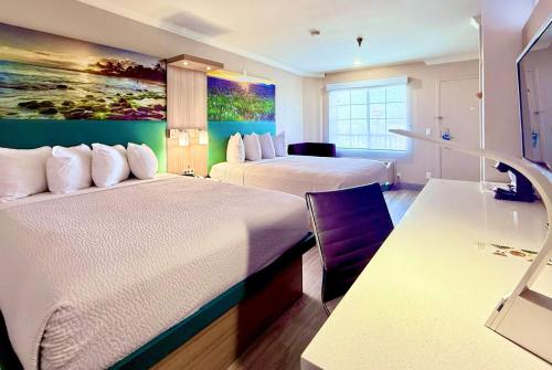 a hotel room with two beds and a painting on the wall at Days Inn by Wyndham Los Angeles LAX/ Redondo&ManhattanBeach in Lawndale