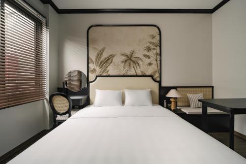 a bedroom with a bed and a painting on the wall at Dom's Residence Hoan Kiem in Hanoi