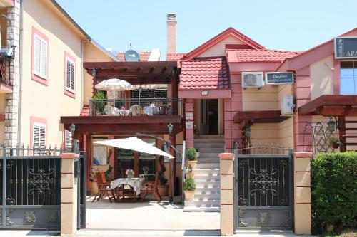 a house with a gate and a table with an umbrella at Apartments Dragović Nikšić in Nikšić