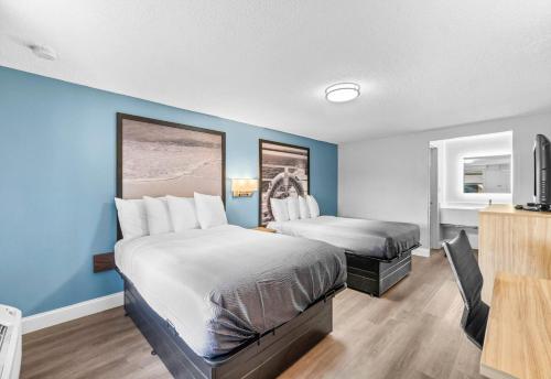 Un ou plusieurs lits dans un hébergement de l'établissement Super 8 by Wyndham Lantana West Palm Beach