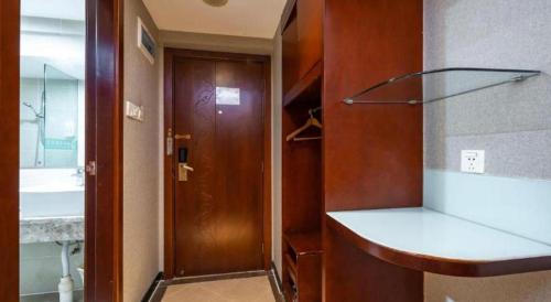 a bathroom with a sink and a wooden door at GreenTree Inn Nanning Langdong Hotel in Nanning